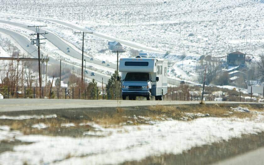 RV traveling on road in the winter.
