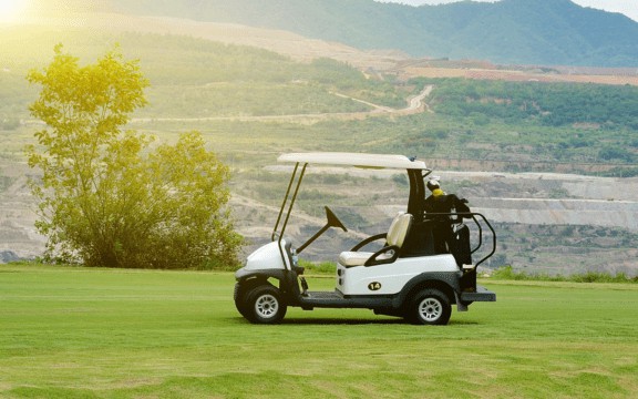 Golf cart in middle of golf course.