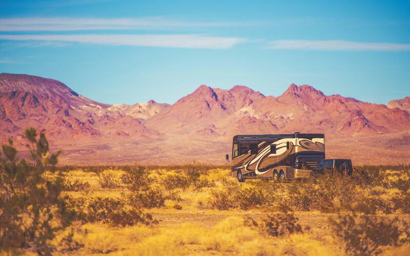 RV boondocking in Arizona desert with hills in background.