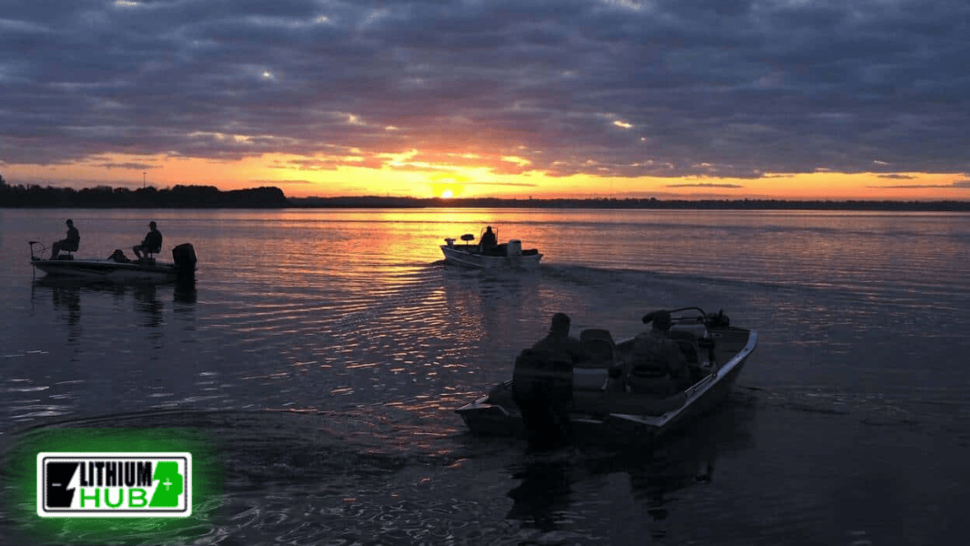 3 Bass boats on lake in the sunset.