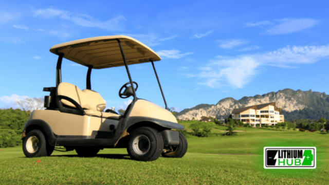 Golf cart on a golf course, with hills and blue sky in the background.