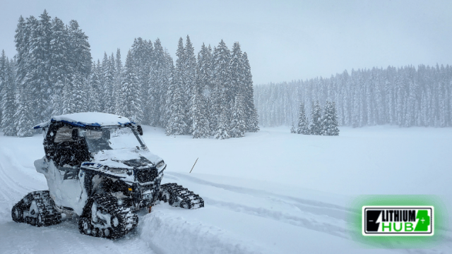 Image of a UTV navigating through a snowy landscape, showcasing its capability in winter conditions.