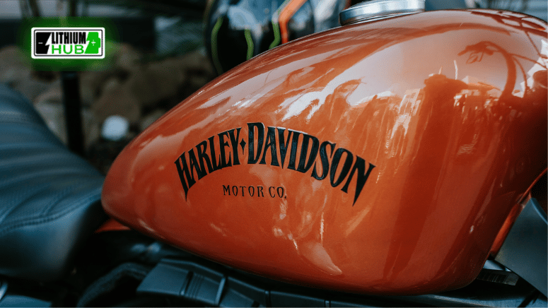 Detailed view of an orange Harley Davidson motorcycle featuring the classic motor logo in focus.