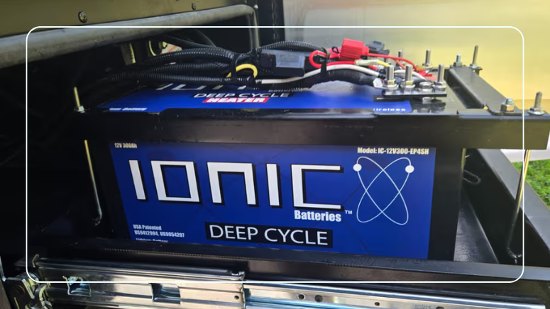 Ionic 12V 300Ah Deep Cycle Heater lithium battery installed in RV battery compartment with wiring and connections