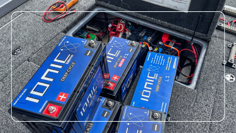 Ionic LiFePO4 deep cycle marine batteries staged beside an open boat battery compartment during a battery bank upgrade