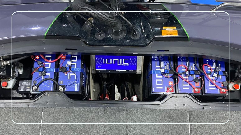 Ionic lithium deep cycle batteries wired in series in a boat battery compartment with an onboard lithium battery charger