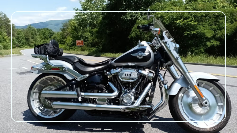 Harley-Davidson Fat Boy 114 cruiser parked on a sunny mountain road, ready to ride