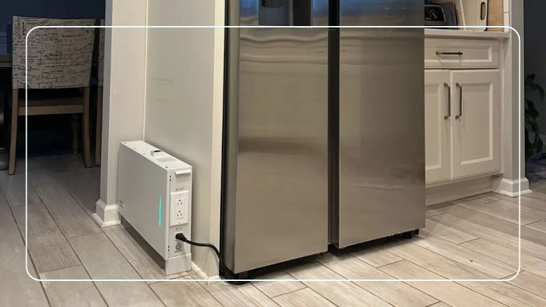 Ionic GenBox 1200S Slim backup battery on the kitchen floor with a refrigerator plugged into it
