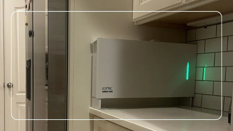 Ionic GenBox 1200S Slim backup battery on a kitchen counter next to a refrigerator
