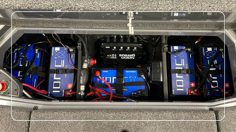 Ionic deep cycle lithium batteries strapped in a boat compartment with a multi-bank onboard charger