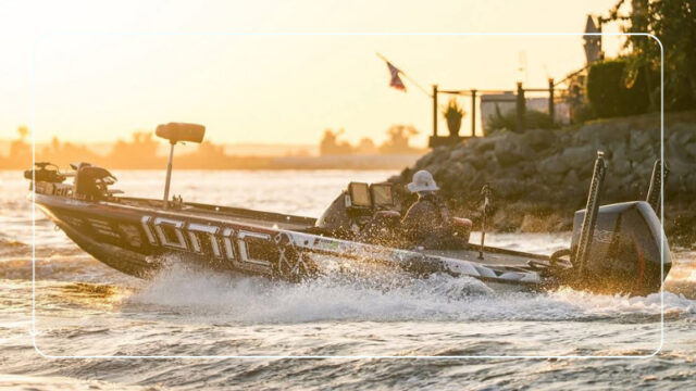 Angler driving an Ionic-wrapped bass boat across the water at sunset