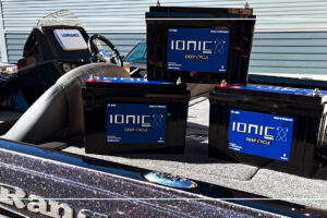 Three Ionic lithium deep cycle batteries staged in a bass fishing boat with a Lowrance fishfinder at the console