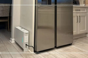 Ionic GenBox 1200S Slim backup battery on the kitchen floor with a refrigerator plugged into it